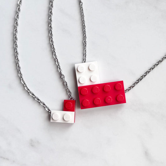 Necklace with red and white LEGO brick pendants on a marble background